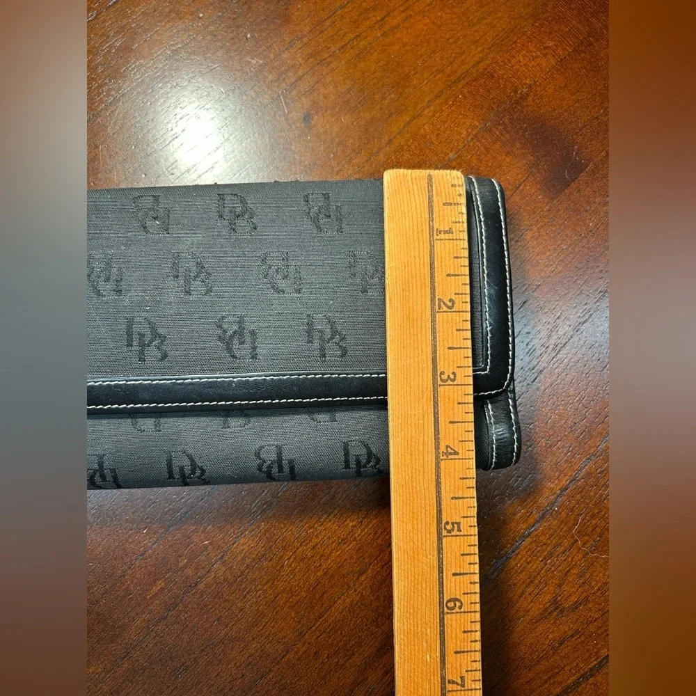 Dooney & Bourke Black Logo Fold Wallet It has a small detail on the inside
